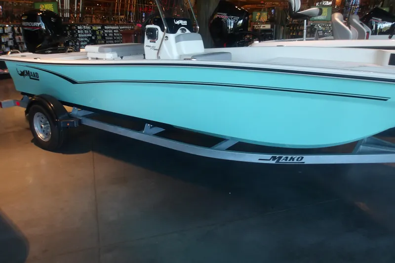 The Image of 2026 Mako Pro Skiff 17 CC boat on trailer, displayed indoors. - 1