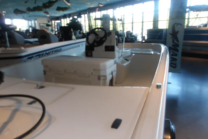 Slide: The Image of 2026 Mako Pro Skiff 17 CC boat displayed in a showroom with modern interior. - 10
