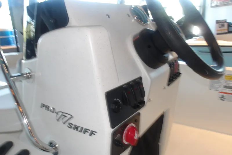 Slide: The Image of 2026 Mako Pro Skiff 17 CC boat console with steering wheel and control panel. - 16