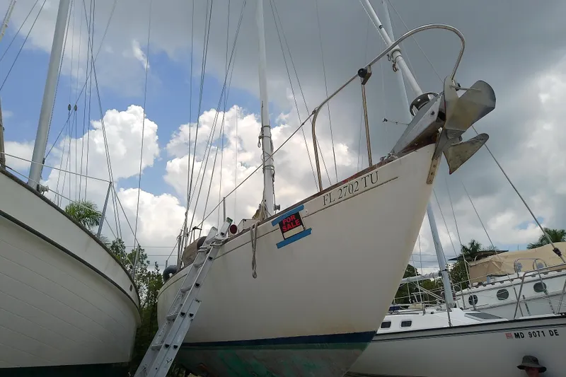 Slide: The Image of 1981 Sea Sprite 34 sailboat on land, for sale, under cloudy sky. - 2
