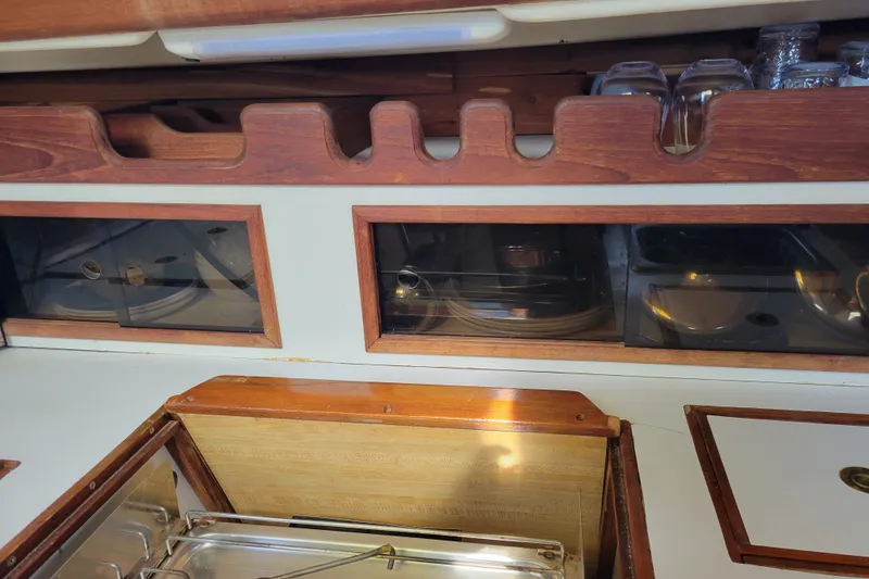 Slide: The Image of Interior of 1981 Sea Sprite 34 sailboat galley with wooden cabinetry and glass storage. - 26