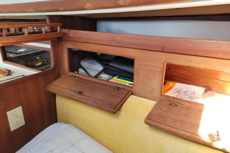 Slide: The Image of Interior storage compartments on a 1981 Sea Sprite 34 sailboat, featuring wooden cabinetry. - 28
