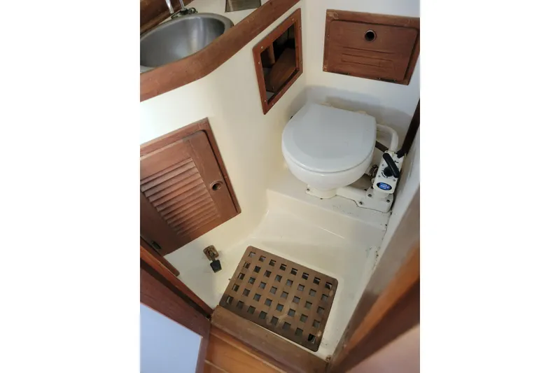 Slide: The Image of 1981 Sea Sprite 34 sailboat bathroom with toilet, sink, and wooden accents. - 32