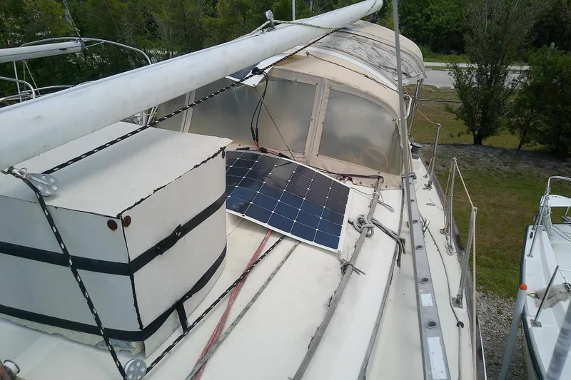 Slide: The Image of 1981 Sea Sprite 34 sailboat with solar panel on deck, docked near trees. - 9