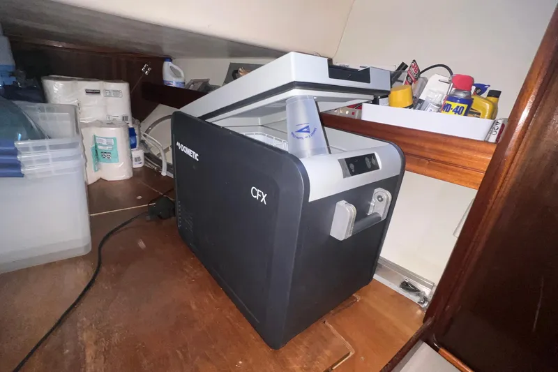 Slide: The Image of Dometic CFX cooler in Bavaria 42 yacht storage, surrounded by supplies and tools. - 9