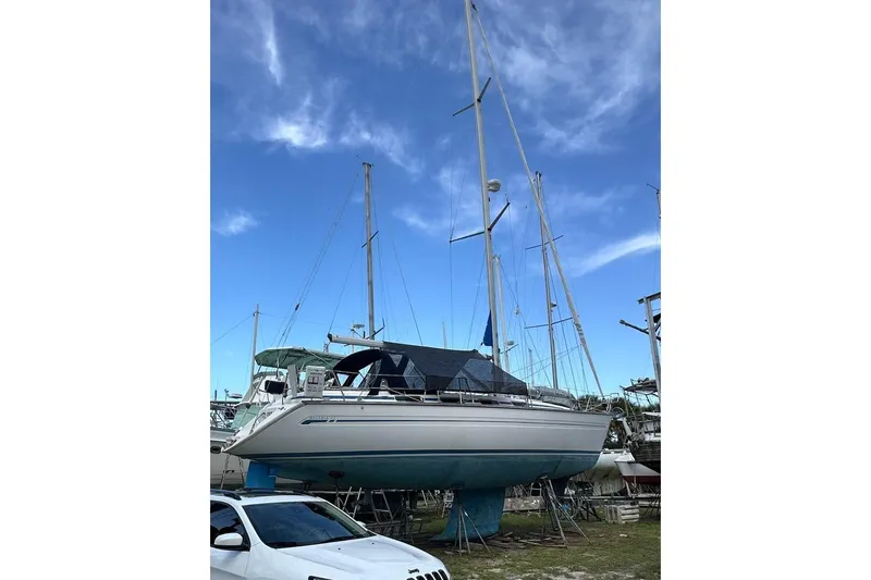 Slide: The Image of Sailboat Bavaria 42, 2001 model, docked on land under a clear blue sky. - 2
