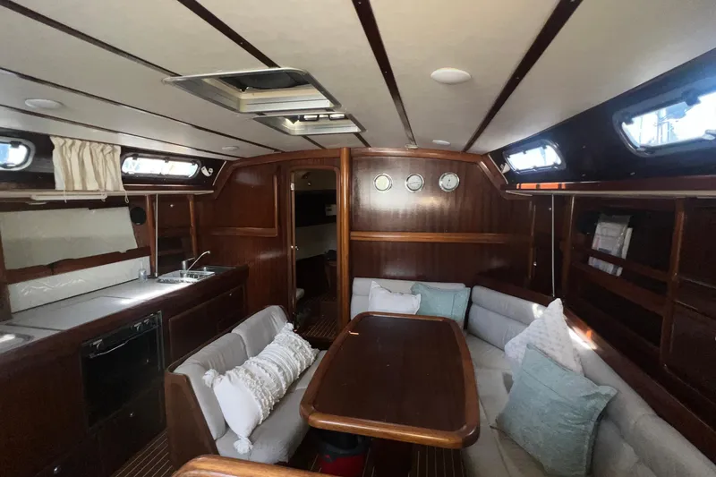 Slide: The Image of Interior of a 2001 Bavaria 42 yacht with cozy seating and wooden finishes. - 16