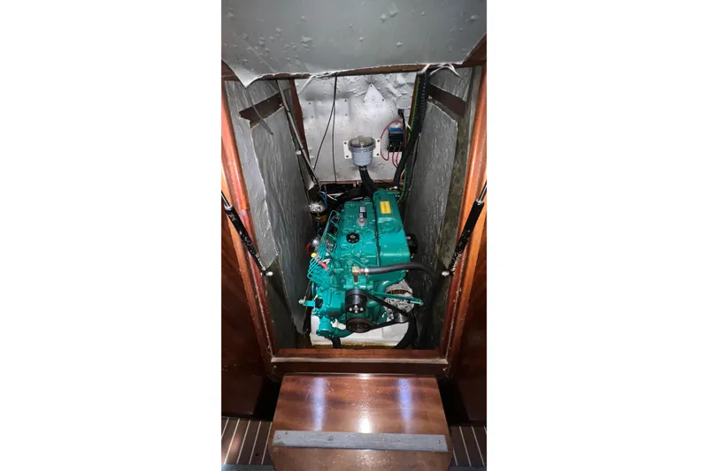Slide: The Image of Engine compartment of a 2001 Bavaria 42 sailboat, featuring a green marine engine. - 12