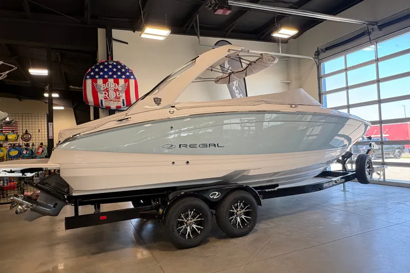The Image of 2027 Regal LS6 boat on trailer in showroom, sleek design, modern features. - 0