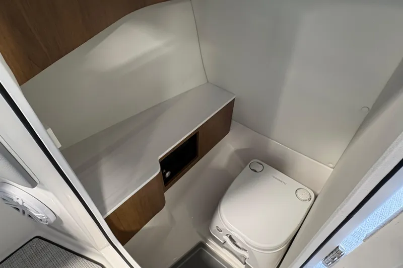 Slide: The Image of Compact bathroom in 2027 Regal LS6 boat with modern fixtures and wood accents. - 14