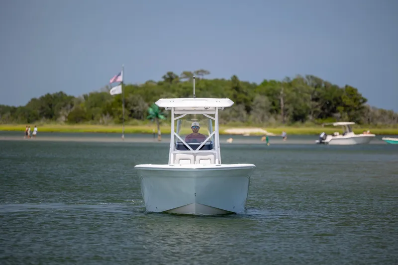 Slide: The Image of 2022 Sea Fox 228 Commander boat cruising on a calm lake with scenic background. - 1