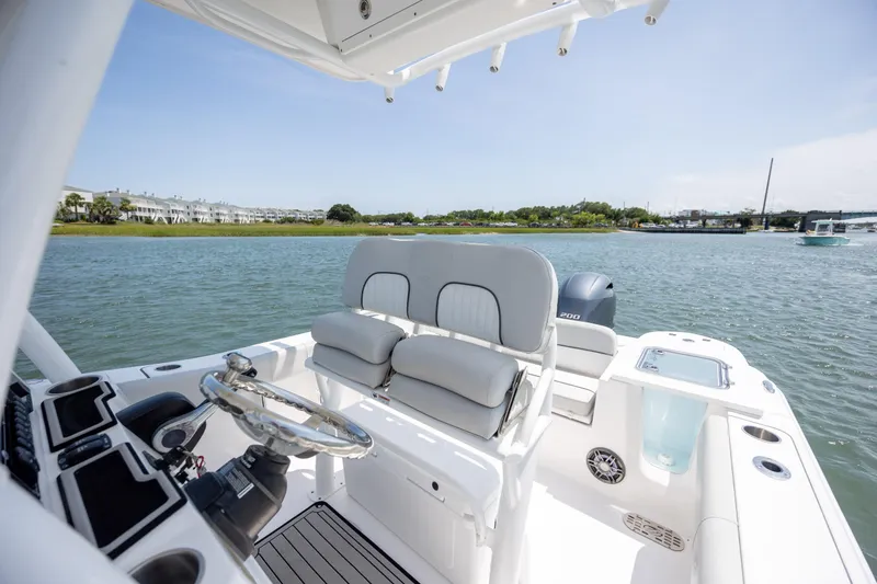 Slide: The Image of 2022 Sea Fox 228 Commander boat interior with helm and seating, on calm water. - 18