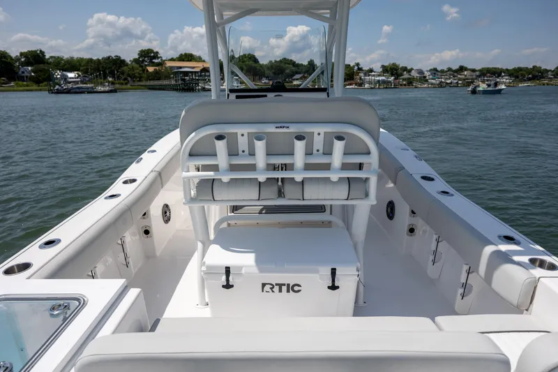 Slide: The Image of 2022 Sea Fox 228 Commander boat interior with rod holders and RTIC cooler on calm water. - 30