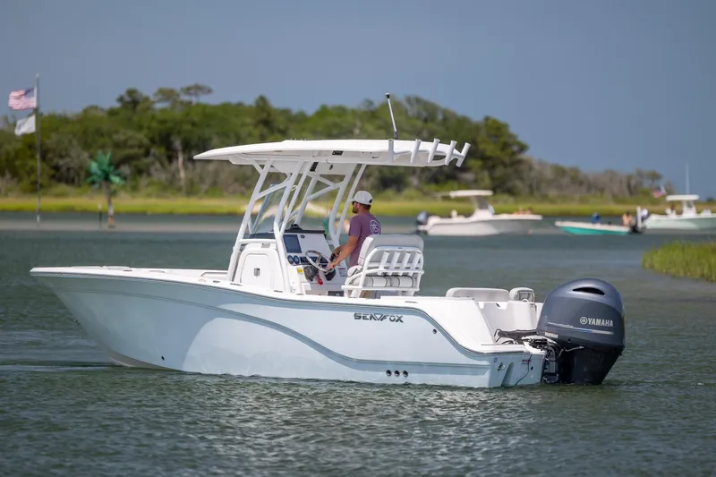Slide: The Image of 2022 Sea Fox 228 Commander boat cruising on a calm waterway with lush greenery. - 5