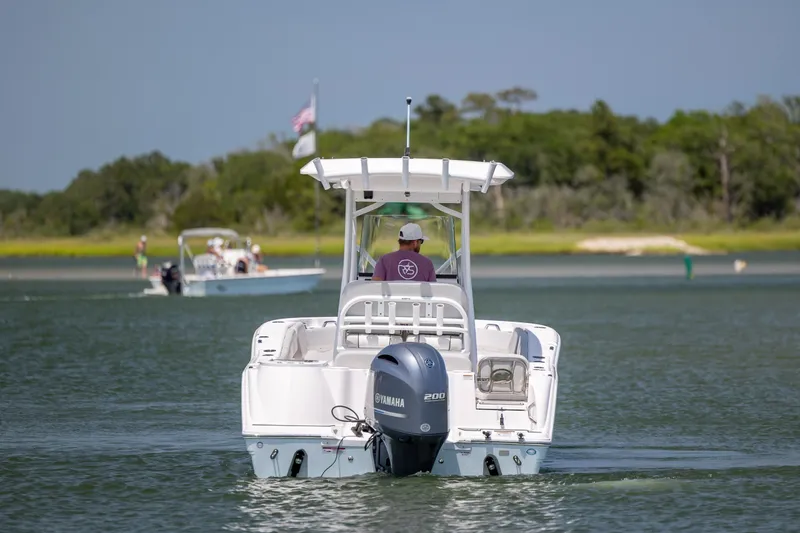 Slide: The Image of 2022 Sea Fox 228 Commander boat cruising on a calm lake with trees in background. - 6