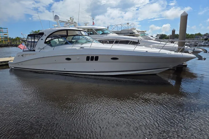 The Image of 2007 Sea Ray 44 Sundancer yacht docked in a marina under a partly cloudy sky. - 1