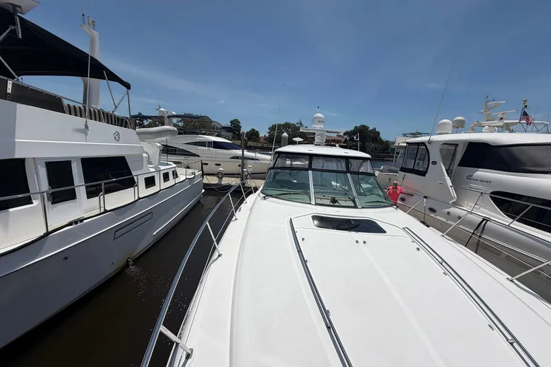 Slide: The Image of 2007 Sea Ray 44 Sundancer yacht docked among other boats on a sunny day. - 13