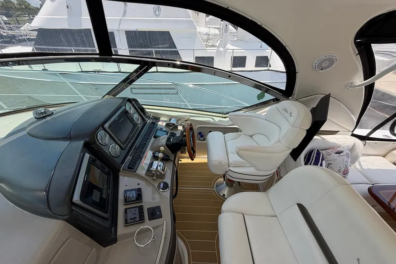 Slide: The Image of 2007 Sea Ray 44 Sundancer helm with luxurious white seating and advanced navigation controls. - 19