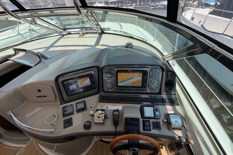 Slide: The Image of 2007 Sea Ray 44 Sundancer helm with navigation screens and controls, docked at marina. - 21