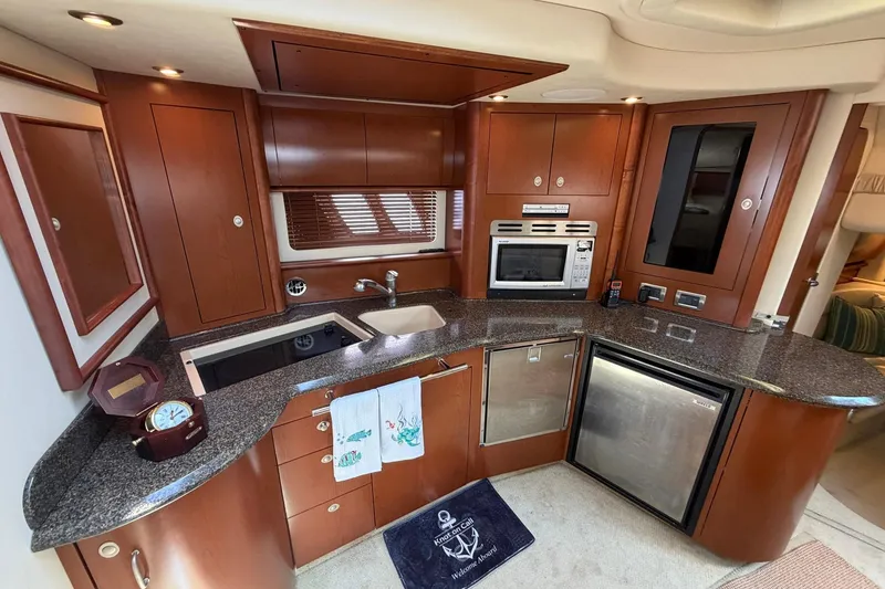 Slide: The Image of Luxurious 2007 Sea Ray 44 Sundancer yacht kitchen with modern appliances and elegant wood cabinetry. - 28