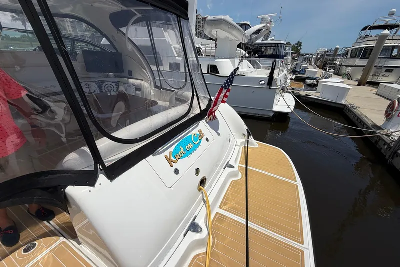 Slide: The Image of 2007 Sea Ray 44 Sundancer docked, featuring a spacious deck and American flag. - 9