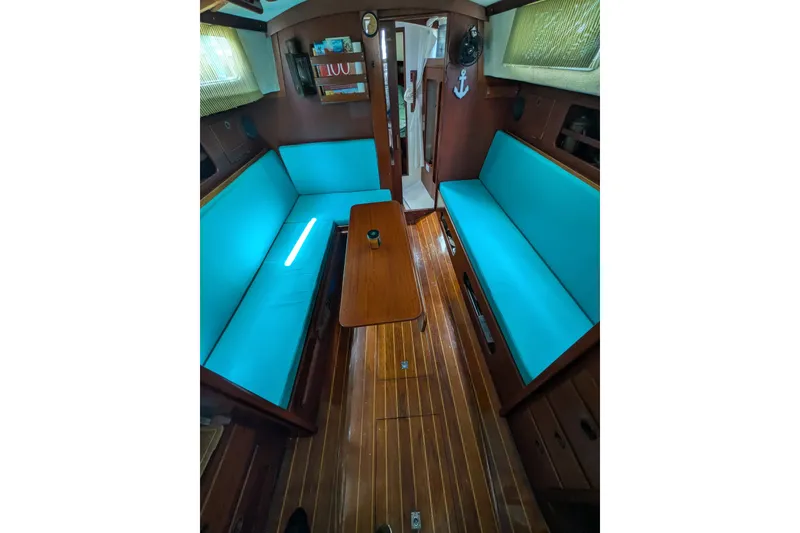 Slide: The Image of Interior of 1978 Hallberg-Rassy Monsun 31 sailboat with turquoise seating and wooden flooring. - 36