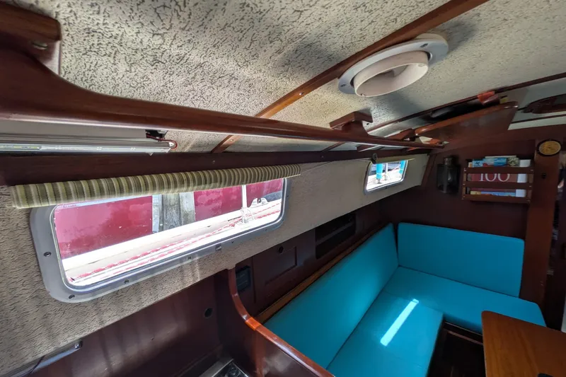 Slide: The Image of Interior of 1978 Hallberg-Rassy Monsun 31 sailboat with blue seating and wooden accents. - 34