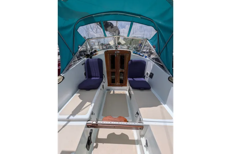 Slide: The Image of 1978 Hallberg-Rassy Monsun 31 sailboat cockpit with blue canopy and cushioned seating. - 39