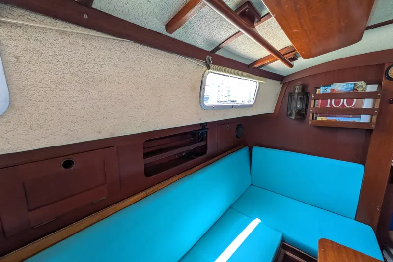 Slide: The Image of Interior of a 1978 Hallberg-Rassy Monsun 31 sailboat with blue cushions and wooden accents. - 35