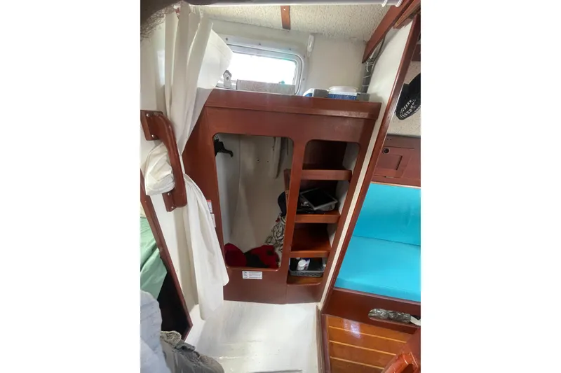 Slide: The Image of Interior of 1987 Hallberg-Rassy Monsun 31 sailboat with wooden shelves and blue seating. - 17