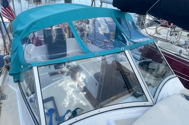 Slide: The Image of 1987 Hallberg-Rassy Monsun 31 sailboat with turquoise canopy and clear windshield in marina. - 8