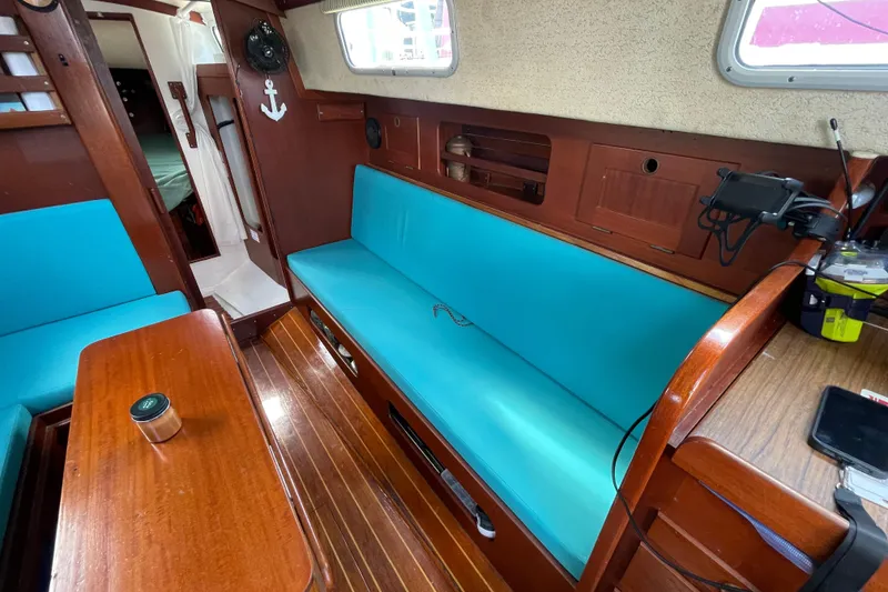 Slide: The Image of Interior of 1987 Hallberg-Rassy Monsun 31 sailboat with turquoise seating and wooden finishes. - 24