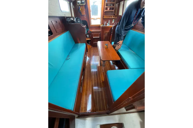 Slide: The Image of Interior of 1987 Hallberg-Rassy Monsun 31 sailboat with turquoise seating and wooden flooring. - 19