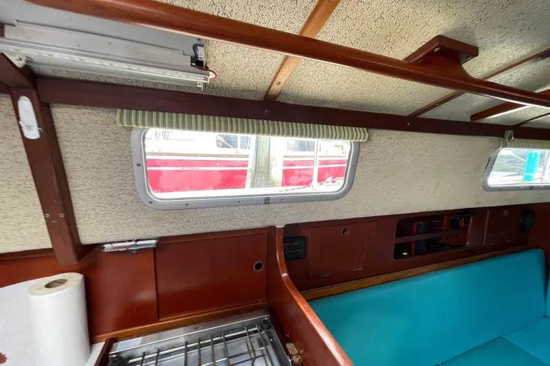 Slide: The Image of Interior of 1987 Hallberg-Rassy Monsun 31 sailboat with teal seating and wooden accents. - 22