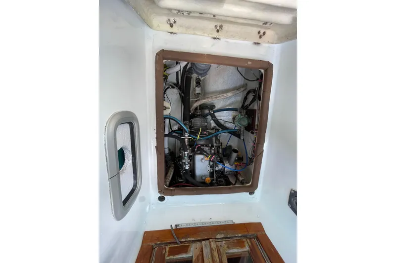 Slide: The Image of Engine compartment of a 1987 Hallberg-Rassy Monsun 31 sailboat, showcasing mechanical components. - 26