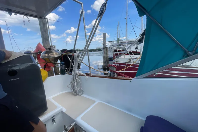 Slide: The Image of 1987 Hallberg-Rassy Monsun 31 sailboat docked, featuring cockpit and marina view. - 11