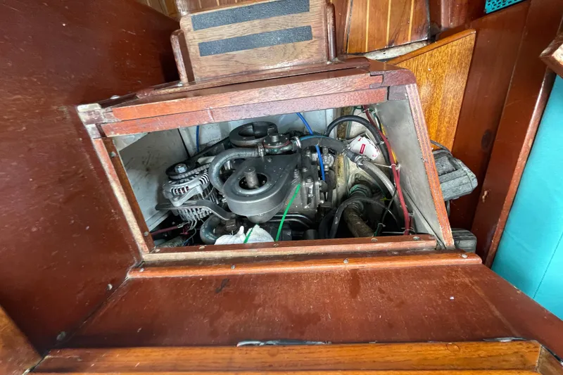Slide: The Image of Engine compartment of a 1987 Hallberg-Rassy Monsun 31 sailboat, showcasing mechanical components. - 20