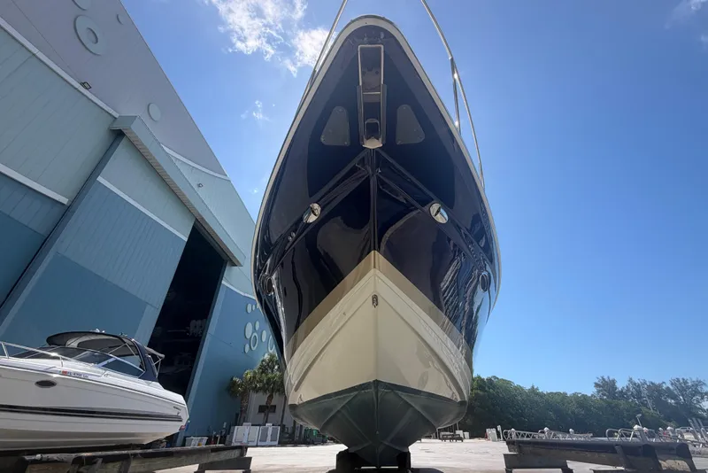 Slide: The Image of 2016 Formula 40 Performance Cruiser boat docked near a large warehouse under a clear blue sky. - 10