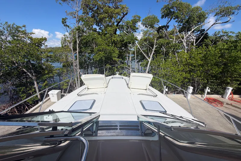 Slide: The Image of 2016 Formula 40 Performance Cruiser docked near lush green trees under a clear blue sky. - 15