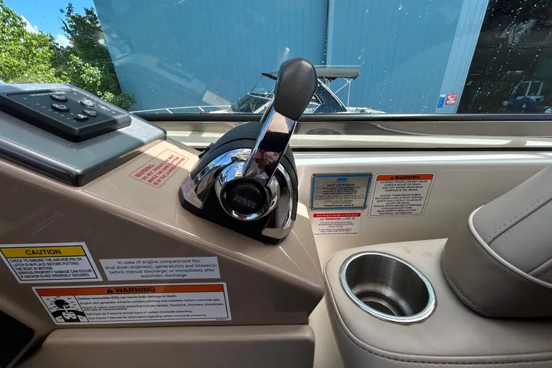 Slide: The Image of 2016 Performance Cruiser Formula 40 cockpit controls with warning labels and cup holder. - 32