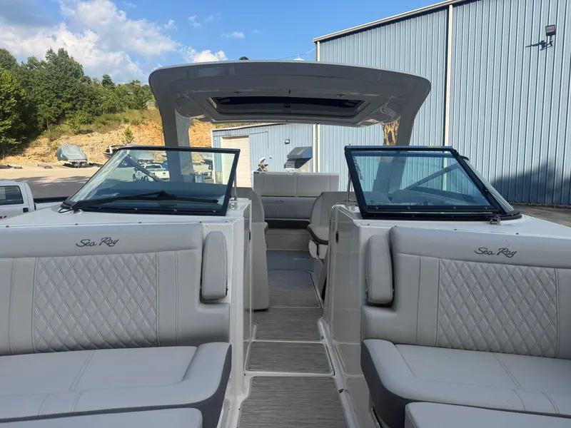 Slide: The Image of 2025 Sea Ray SLX 350 with luxurious seating and open roof, parked outdoors. - 25