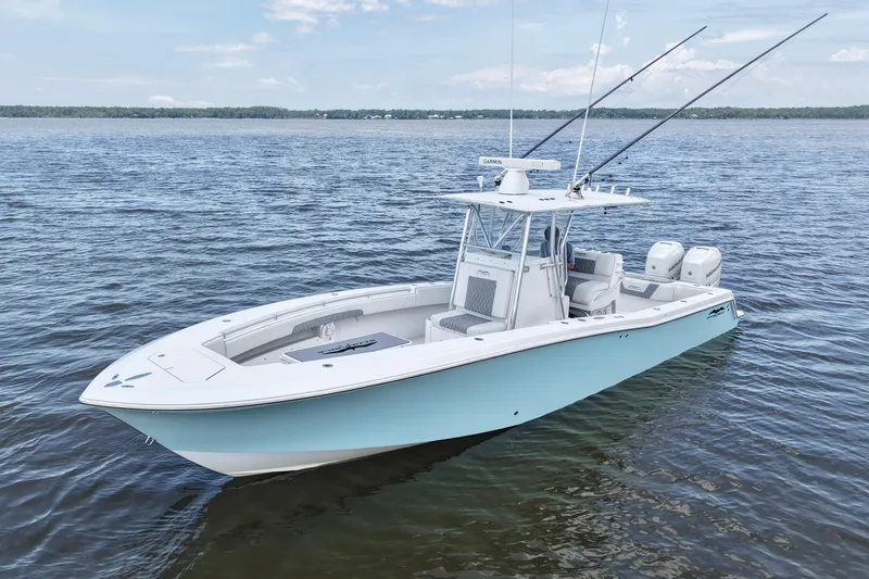 Slide: The Image of 2008 Invincible 33 Open Fisherman boat on calm water, featuring dual engines and fishing rods. - 15