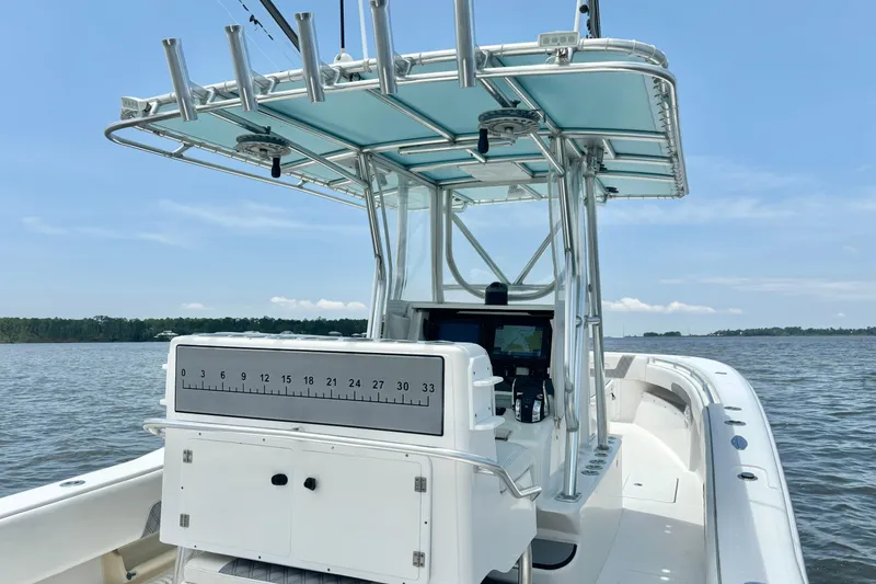 Slide: The Image of 2008 Invincible 33 Open Fisherman boat on calm water, featuring a sleek console and rod holders. - 25
