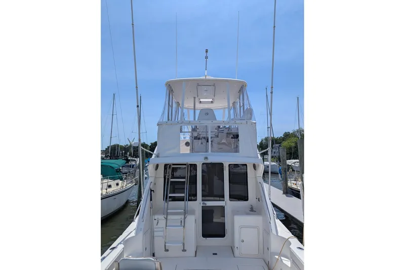 Slide: The Image of 2007 Riviera 33 Flybridge yacht docked at marina, showcasing rear view and flybridge. - 58