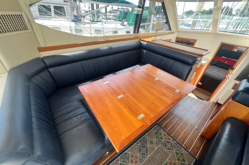 Slide: The Image of Luxurious interior of 2007 Riviera 33 Flybridge yacht with elegant seating and wooden table. - 13