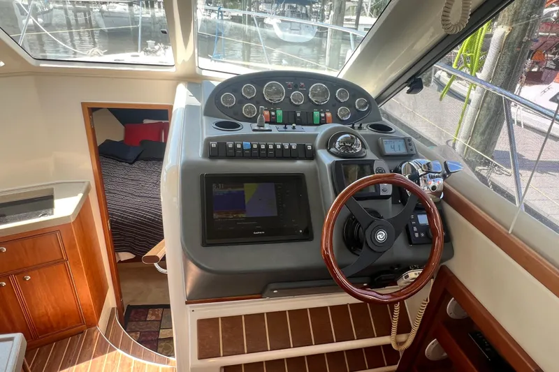 Slide: The Image of 2007 Riviera 33 Flybridge helm with navigation controls and cozy cabin view. - 17