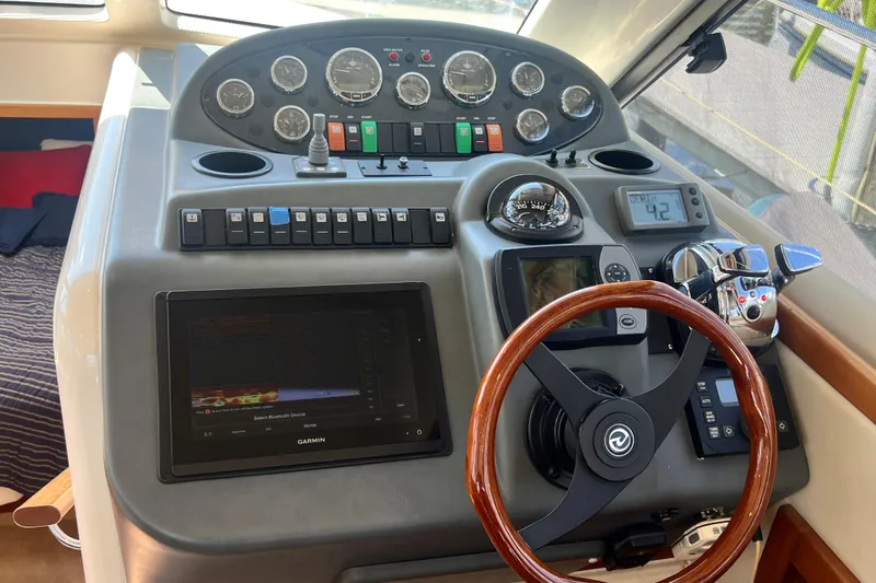 Slide: The Image of 2007 Riviera 33 Flybridge helm with gauges, controls, and Garmin navigation system. - 18