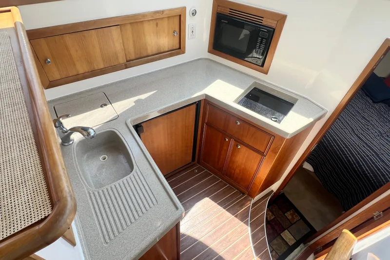 Slide: The Image of 2007 Riviera 33 Flybridge yacht kitchen with sink, stove, and microwave. - 21