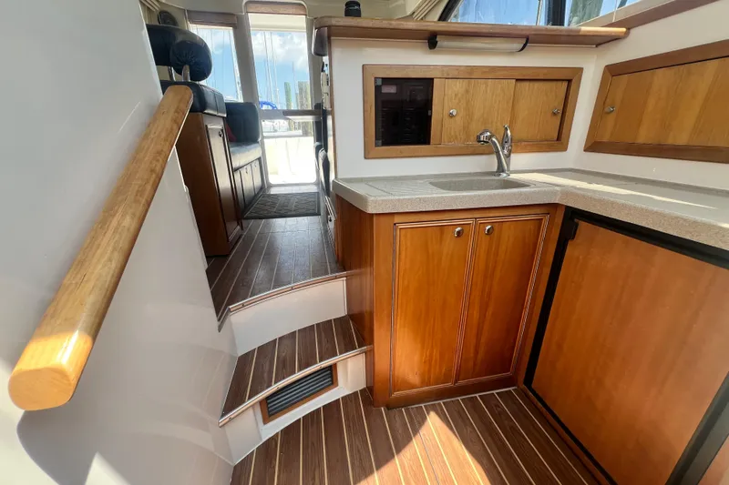 Slide: The Image of Interior of 2007 Riviera 33 Flybridge yacht with wooden cabinetry and compact kitchen area. - 25