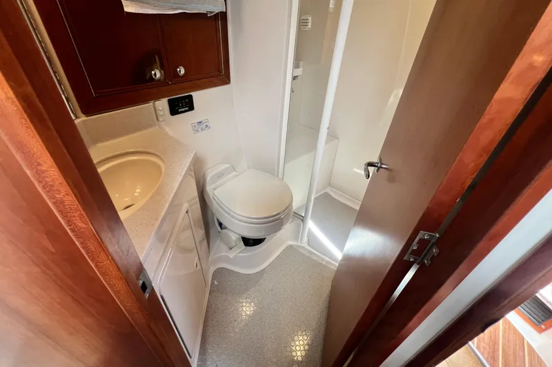 Slide: The Image of Compact bathroom in 2007 Riviera 33 Flybridge yacht with sink, toilet, and shower. - 29